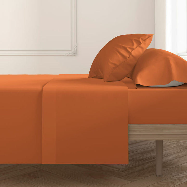 Orange Kissenbezüge (2 Stk.) auf einem Bett. Happy Home Textilien mit glatter Oberfläche.