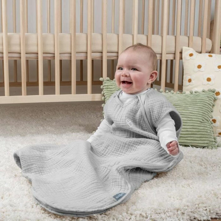 Baby im grauen Ingenuity Schlafsack (6-18 Monate). Ärmellos und weichem Stoff für Komfort.