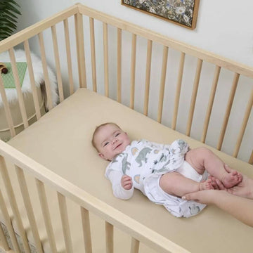 Baby im Gitterbett, trägt Baumwolle Schlafsack mit Elefantenmuster. Schlafsack für 6-12 Monate.