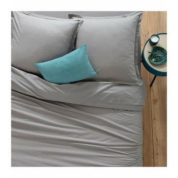 Graues Spannbetttuch auf einem Bett mit passenden Kissenbezügen. Weiche Textur.