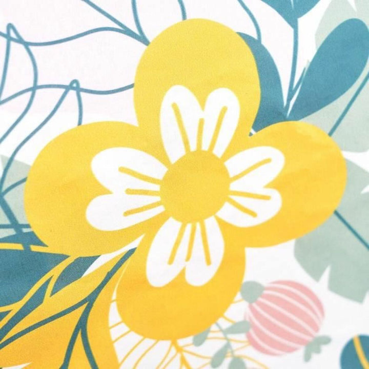 Nahaufnahme: Bunter Bettdeckenbezug mit blumigem Muster und gelber Blume.