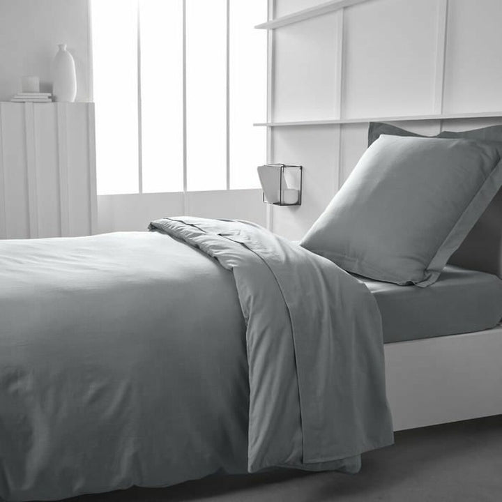 Helles graues Jersey Spannbetttuch 90x190 cm auf einem Bett. Weiche Textur.