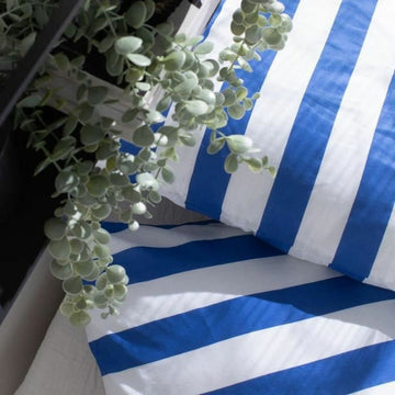 Blau gestreifter Bettdeckenbezug im Sommer-Design mit klaren Linien.