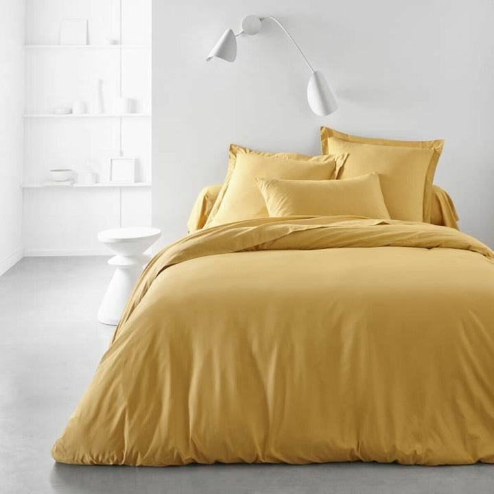 Gelber TODAY Essential Kissenbezug (63x63 cm) auf dem Bett. Schlichtes, modernes Design.