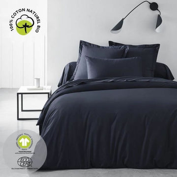 Marineblauer Kissenbezug auf einem Bett. Glatte, hochwertige Baumwolle für ein luxuriöses Schlaferlebnis.