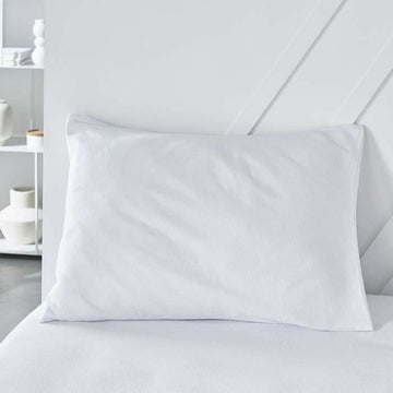 Weißer Kopfkissen-Schutz Essential 50x70 cm auf einem Bett.