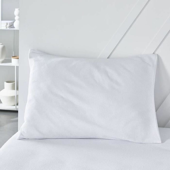 Weißer Kopfkissen-Schutz Essential 50x70 cm auf einem Bett.