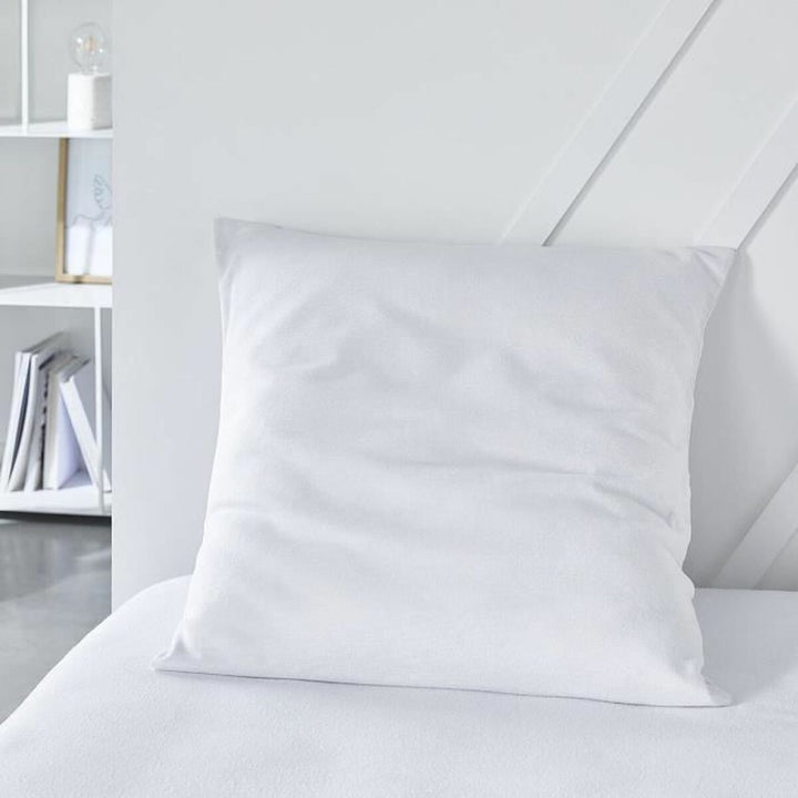 Weißer, absorbierender Kopfkissen-Schutz auf einem Bett für Hygiene und Komfort.