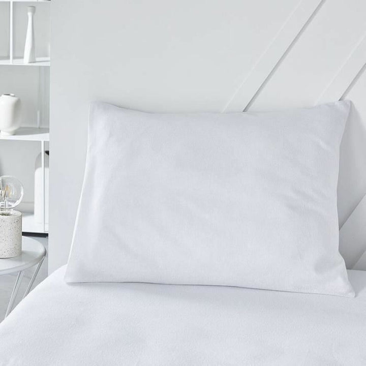 Weißer Kopfkissen Schutz auf einem Bett. Rechteckiger Kissenbezug für Hygiene.