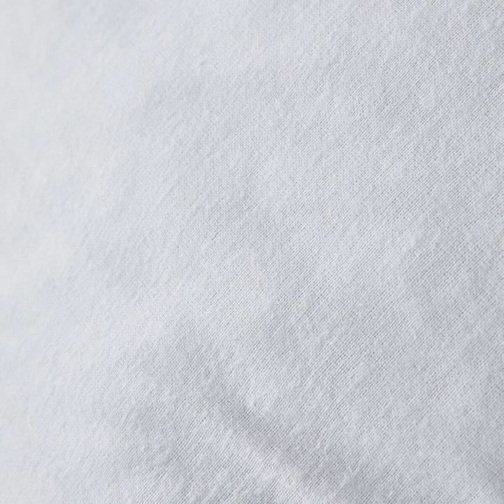 Nahaufnahme: Weißer Kopfkissen-Schutz mit feiner Textur.