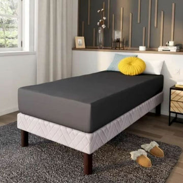 Anthrazit Bettlaken DODO 90x190 auf einem Einzelbett. Glatte Textur und dunkle Farbe des Spannbettlakens.