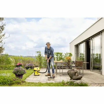 Gelber Kärcher WD 2-18 V-12/18 Nass- und Trockensauger im Einsatz auf einer Terrasse.