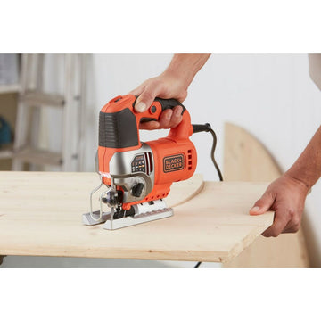 Orange Black & Decker Laubsäge in Aktion. Silberbasis und sichtbares Kabel.
