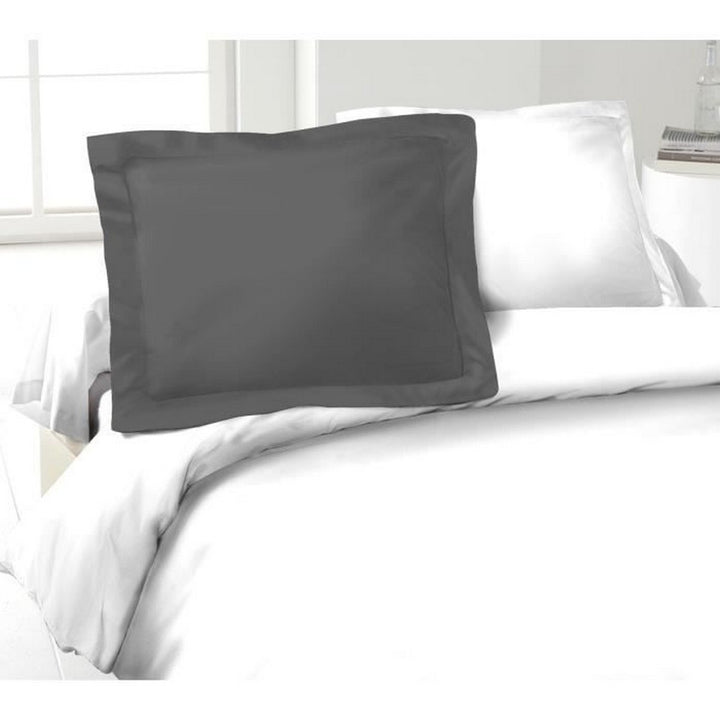 Dunkelgrauer Kissenbezug (50x70 cm) aus 100% Baumwolle auf einem Bett mit weißer Bettwäsche.