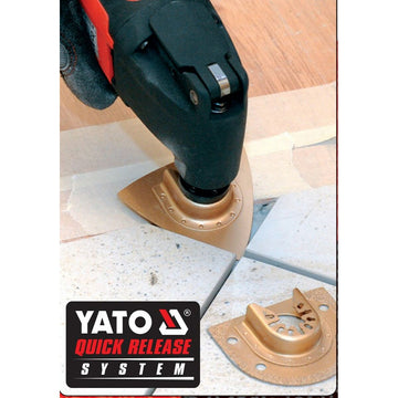 Yato Multiwerkzeug YT-82220 schneidet Fliesen. Das Werkzeug hat ein Quick-Release-System und goldene Klinge.