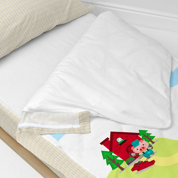 Bunter Bettbezug mit Füllung mit Schweinchen-Motiv. Kinderfreundliches Design mit Haus und Bäumen.
