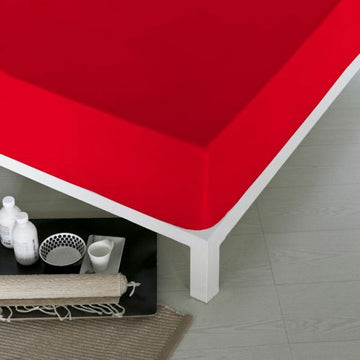 Nahaufnahme: Rotes Spannbetttuch Naturals auf einem Bett. Kräftige Farbe und glatte Textur.