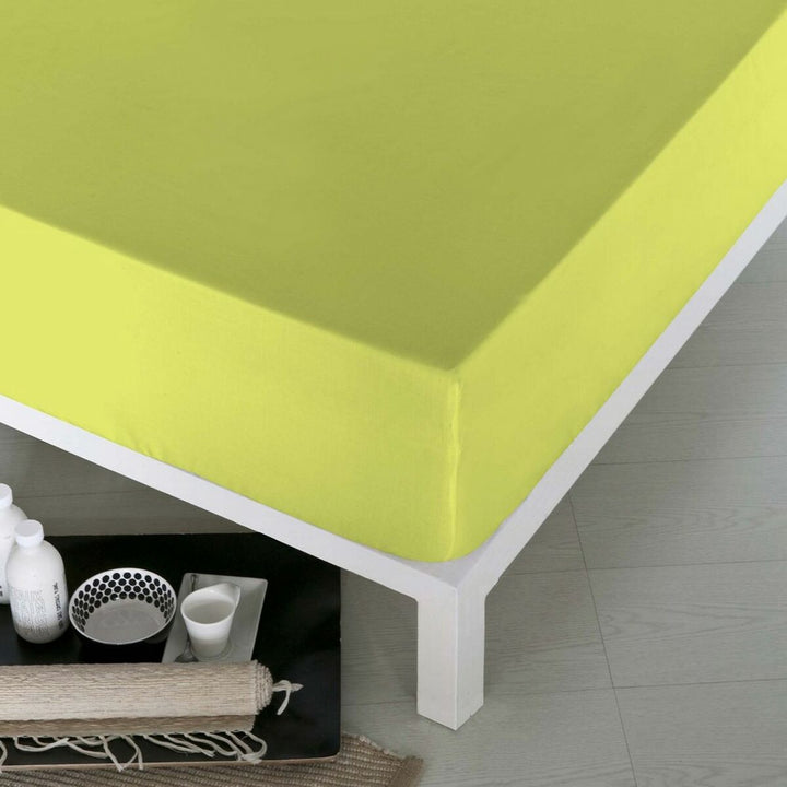 Pistazienfarbenes Spannbetttuch Naturals auf einem Bett. Glatte Textur des Spannbettlakens.
