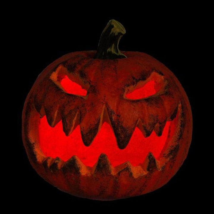 Gruselige Deko-Figur: Halloween Kürbis mit geschnitztem Gesicht und rotem Licht.