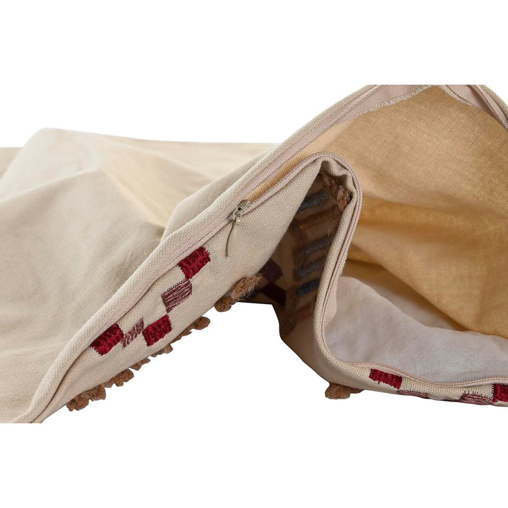 Nahaufnahme: Beige Kissenbezug mit Reißverschluss und bestickten Details.