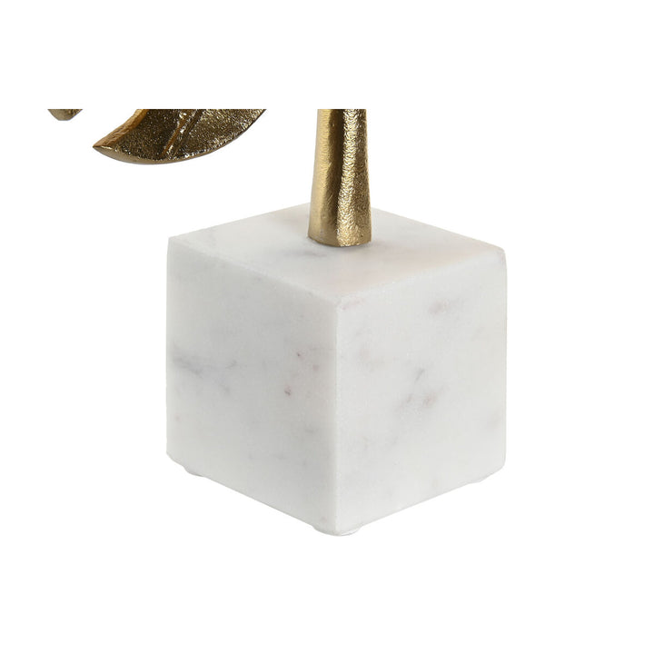Goldfarbene Deko-Figur mit tropischem Pflanzenblatt auf weißem Sockel.