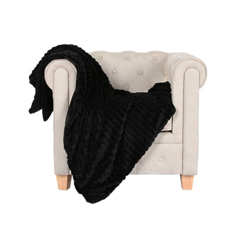 Schwarze ESPRIT Home Decke mit Rippenmuster auf beigem Sessel drapiert.