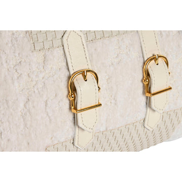Nahaufnahme: Weißes Esprit Home Kissen mit goldenen Schnallen und dekorativer Textur.