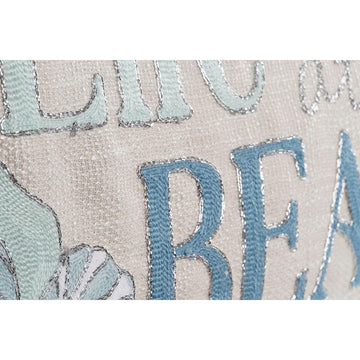 Nahaufnahme: Mediterranes ESPRIT Beach Kissen mit blauer Schrift und Muschel Design.