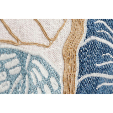 Nahaufnahme: Mediterranes Kissen mit Meeresschnecken-Stickerei. Blaue und beige Details.