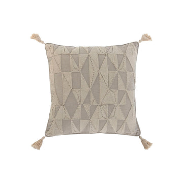 Naturfarbenes Kissen im Boho-Stil mit geometrischen Mustern und Quasten an den Ecken.