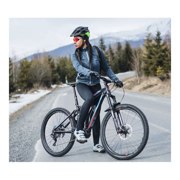 Schwarzes Mountainbike mit dicken Reifen und sportlichem Design auf einer Landstraße.