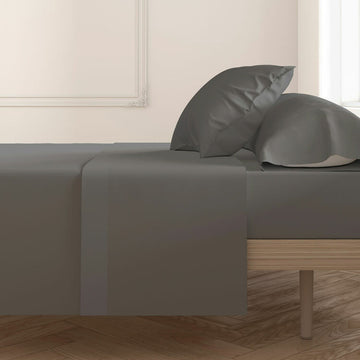 Anthrazit Kissenbezug Happy Home (2 Stück) auf einem Bett. Glatte Textur.