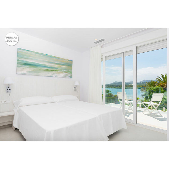 Weißes Hosteline IRIS PREMIUM Bettwäsche-Set auf Doppelbett mit Meerblick.