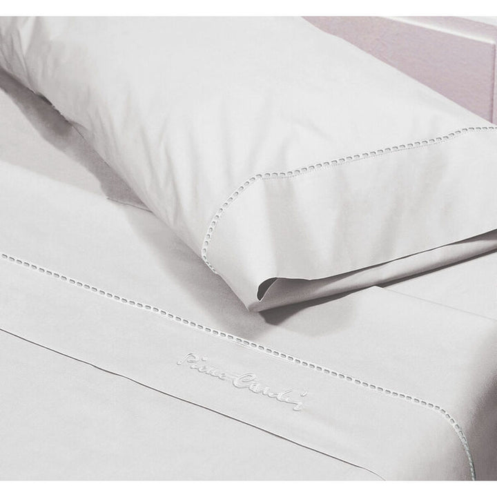 Weißes Pierre Cardin Bettwäsche-Set mit Ziernähten und Logo für Einzelmatratze.