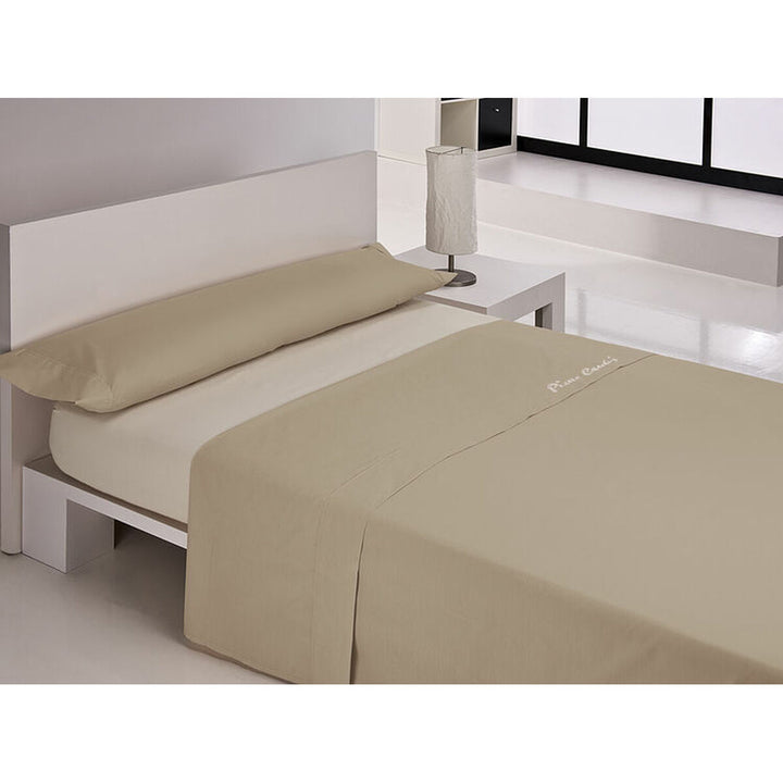 Beige Pierre Cardin Bettwäsche-Set auf Einzelmatratze mit Kissen und dezenter Signatur.