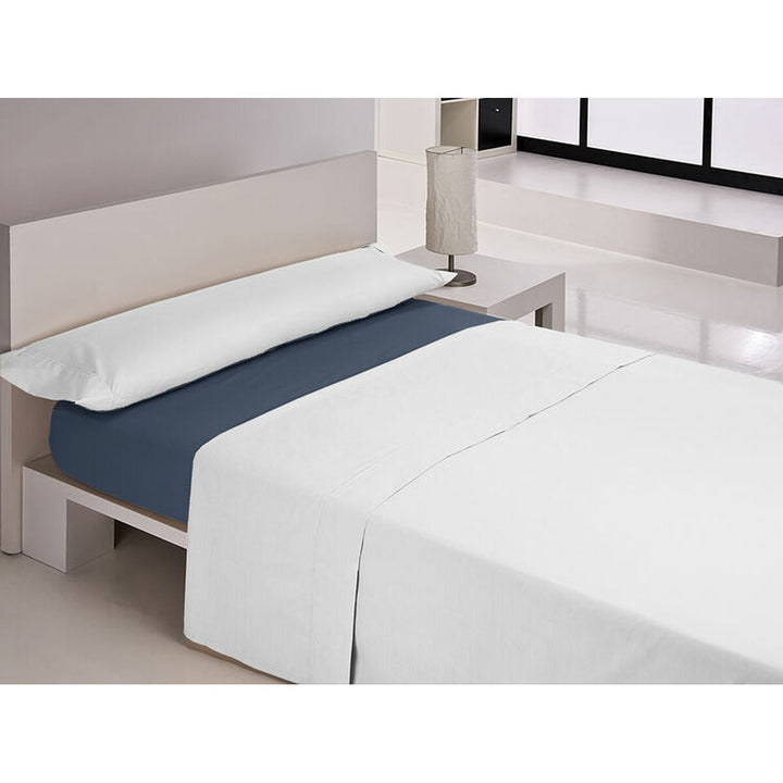 Blaues Spannbetttuch auf Einzelmatratze mit weißen Bettlaken in minimalistischem Schlafzimmer.