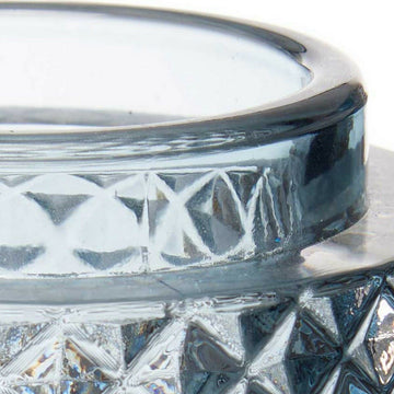 Nahaufnahme: Blaue Kerzenschale aus Glas mit geometrischem Muster.