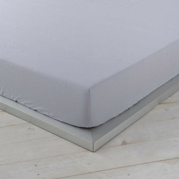Graues Naturals Spannbetttuch auf einem Bett, weiche Textur.