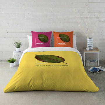 Gelber Bettdeckenbezug Nature Pantone mit Blätterdruck und farbigen Kissenbezügen.