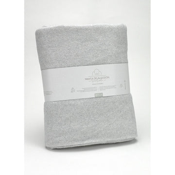 Helle, perlgraue Decke aus recycelter Baumwolle. Weiche Textur und nachhaltige Produktion.