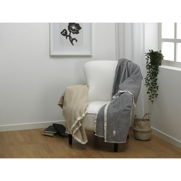 Alexandra House Living Decke Lares perlgrau auf Sessel. Grau und Beige Decke mit Fransen.