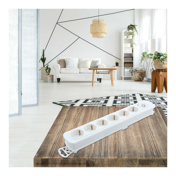Weiße Steckerleiste mit 6 Steckdosen und Schalter auf einem Holztisch.