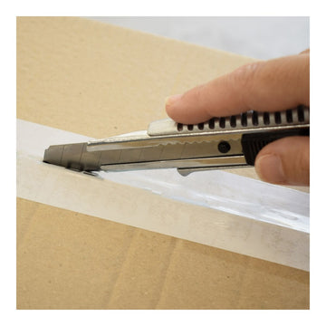 Ferrestock Cutter schneidet Klebeband auf Karton. Silberklinge und schwarzer Griff.