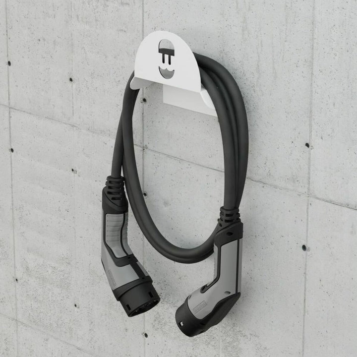 Weiße Wandhalterung für Wallbox mit grauem Ladekabel und Stecker. Praktische Kabelaufbewahrung.