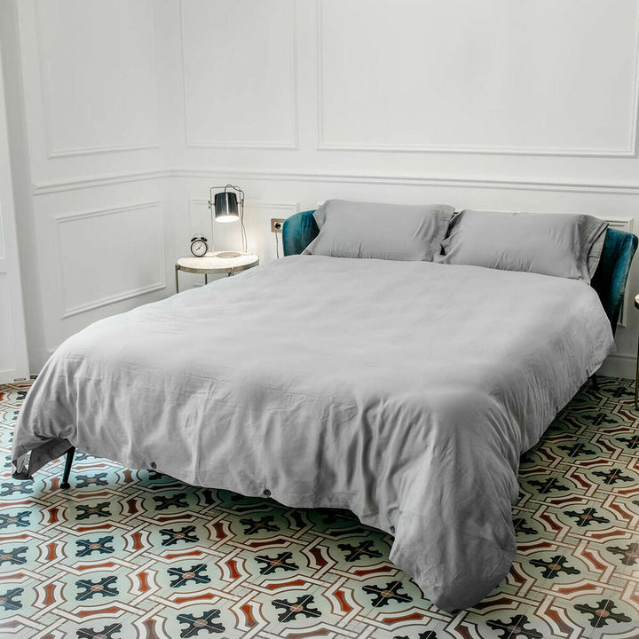 Grauer Tencel Bettdeckenbezug in Doppelgröße (220x220 cm) auf einem Bett.