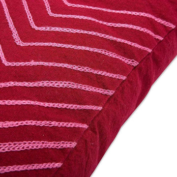 Rotes Kissen mit rosa Ziernähten. Dekoratives Kissen mit strukturiertem Stoff.