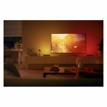 Philips Play Lichtleiste Set in Weiß, die TV-Umgebung mit farbiger Beleuchtung akzentuiert.