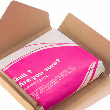Kissen mit pink-weißem Bezug in Kartonverpackung. Blickfangendes Design mit Text.