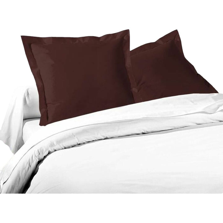 Braune Kissenbezug-Set (2 Stück) 63x63 cm auf einem Bett. Lovely Home Kissenbezüge.