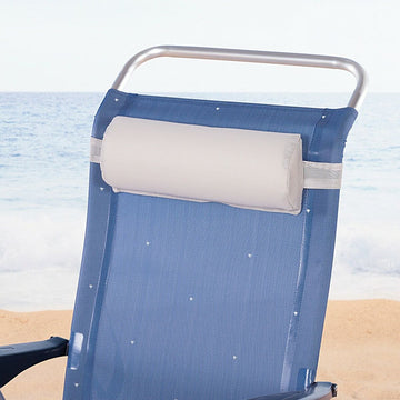 Graues Stuhl-Kissen als Kopfstütze an blauem Stuhl mit Meer im Hintergrund.